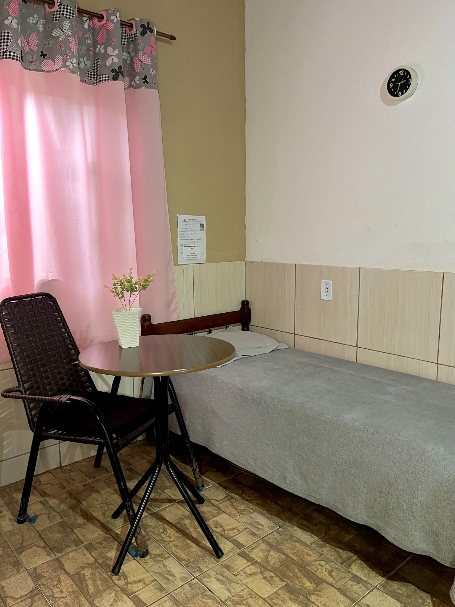 Quarto individual aconchegante com leito e mesa de apoio